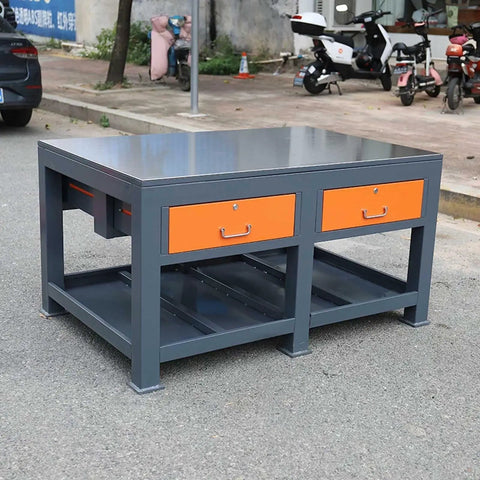 Industrial Grade Steel Workbench Featuring Two Secure Locking Drawers And Quick Access Shelf Built Tough For The Daily Grind Rock Solid Assembly Table For Garage And Warehouse Use displayed outdoors.