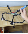Helping Hands Soldering Tool With Flexible Gooseneck Arms holding PCB on workbench, 360 Degree Alligator Clips, in use.