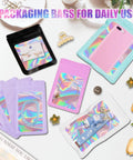 Colorful holographic packaging bags with clear windows, showcasing jewelry and small gifts, flat lay with flowers and accessories.