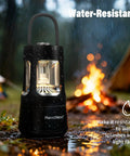 Outdoor Camping Lantern With Built In Bluetooth Speaker And Waterproof Shell next to a campfire in a rainy setting.