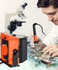 Man using Solder Smoke Absorber Kit With Tiltable Fume Extractor and Flexible Helping Hands for precise circuitry work.