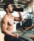 Man using 24oz Insulated Water Bottle Built Tough With Premium Stainless Steel And Double Wall Vacuum in gym environment.