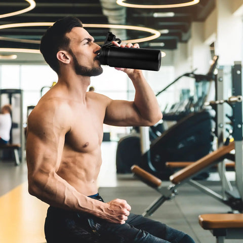 Man using 24oz Insulated Water Bottle Built Tough With Premium Stainless Steel And Double Wall Vacuum in gym environment.