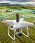 Drone equipped with Four System GNSS Helix Antenna For GPS BeiDou GLONASS Galileo With 28dB High Gain, flying over farmland.