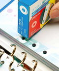 Applying Clear Hole Reinforcement Stickers Pack 1000 Count 4 Boxes Of 250 Easy Peel Self Adhesive on binder pages.