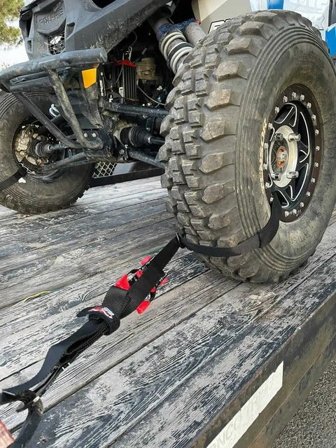 Close-up of UTV tire secured on trailer using Ultimate UTV Tie Down Kit For Trailer Transport With Tire Bonnets, showcasing the installation.
