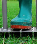 Manual Lawn Aerator Spike Tool With 15 Iron Spikes in use on grass with boot on metal plate