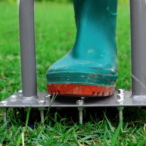 Manual Lawn Aerator Spike Tool With 15 Iron Spikes in use on grass with boot on metal plate