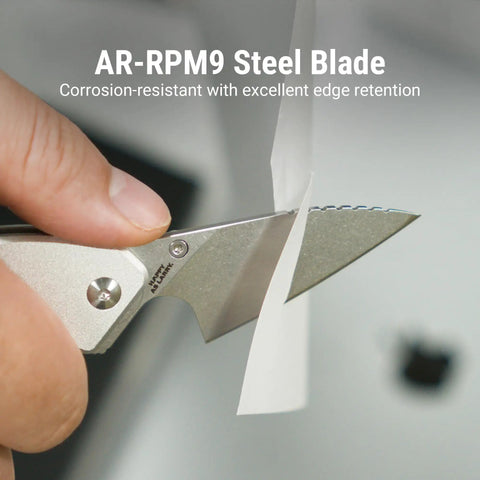 Close-up of Spud Small Neck Knife with AR-RPM9 Steel Blade cutting paper, aluminum handle in raw silver.