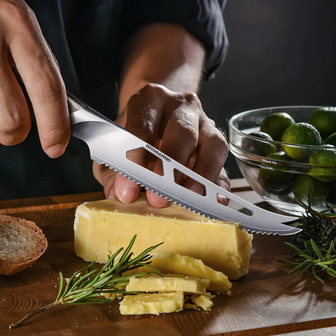 Five Inch Serrated Cheese Knife Crafted With Premium Steel Core And A Super Slick Hollow Blade For Butter Smooth Cuts That Slide Off Easy Plus A Gotta Have Fork Tip For Zero Mess Party Spread, slicing cheese on a wooden board.