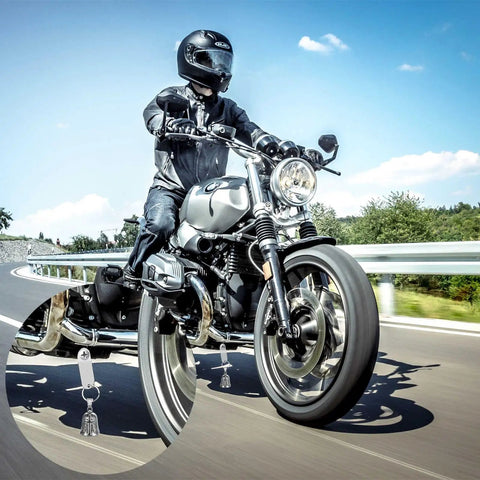 Motorcycle on road zoom-in showing Two Pack Motorcycle Bell Set With Gift Box And Legend Card, Weatherproof Badass Good Luck Charm For Riders.