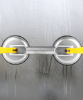 Super Heavy Duty 2 Jaw Glass Suction Cup Lifter Tool With Spring Loaded Locking Handle, aluminum and rubber, on wet surface.