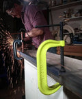 Hi Vis C Clamp With Ten And One Eighth Inch Opening And Six Inch Throat Eight Thousand Pounds Clamping Force Heavy Duty Drop Forged Steel Powder Coated Yellow OSHA Color Model 410 SF Beefy Shop Grade in use by worker with sparks.