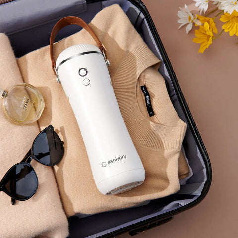 Portable Electric Clothes Dryer With Shoe Drying Attachment And Foldable Drying Rack in suitcase with sweater and accessories.