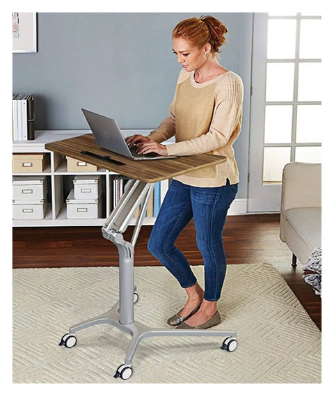 Woman using Adjustable Mobile Overbed Table Featuring Smooth Rollin Casters And Beastly Stable Base for remote work.
