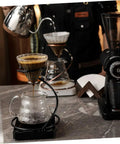 Kick Up Your Morning Brew Game With This Slick Two Piece Coffee Dripper Stand in action with brewing coffee.