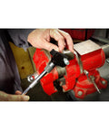 Side view of Powerbuilt universal thread repair tool 5/32–3/4 in SAE, 4–19 mm metric, held near a red vise.