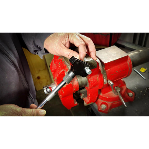 Side view of Powerbuilt universal thread repair tool 5/32–3/4 in SAE, 4–19 mm metric, held near a red vise.