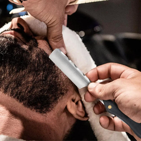 Premium Straight Razor And Leather Shaving Strop Set With Sharp Stainless Steel Blade And Smooth Wooden Handle For Men being used on a man's beard during a grooming session.