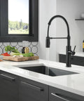 Heavy Duty Slick Finish Kitchen Faucet With Smooth Pull Down Spray Single Handle Matte Black Build in modern kitchen with vegetables.