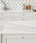 Five Pack Brushed Nickel Square Cabinet Knobs And Kitchen Drawer Pulls Hella Durable Rust Resistant Hardware For The Modern Farmhouse Bathroom Vanity Decor Set on white countertop with herringbone backsplash.