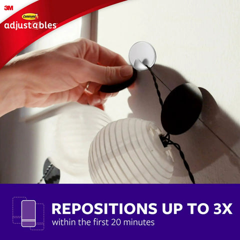 Repositionable Wall Decor Clip Kit With 8 Spring Clips And 24 Mini Squares, White Finish, being adjusted on a wall.