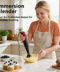 Premium Corded Handheld Immersion Blender Equipped With A 15000Rpm Motor And Razor Sharp Stainless Blades For No Sweat Soup Mixing And Smooth Purees In Every Kitchen, blending batter in clear bowl.