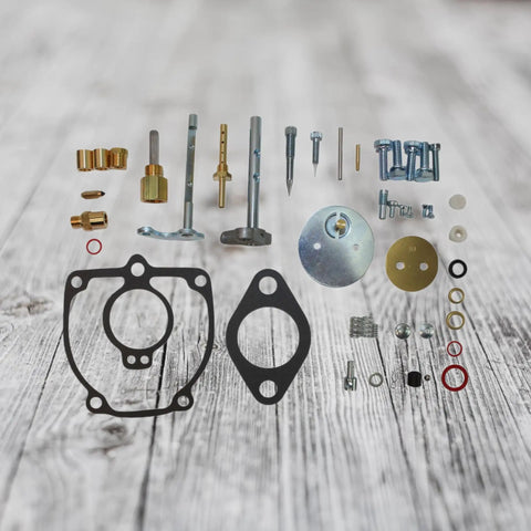 Beefed Up Carburetor Repair Kit For 656 706 756 Tractor with shafts, gaskets, and float components displayed on wood surface.