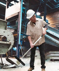 Man using Heavy Duty Telescoping Magnetic Pick Up Tool 27 To 44 Inches, 57 Lb Pull Magnetic Nail Sweeper in industrial setting.