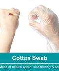 Cotton swab with white stick held by gloved hand; close-up view.