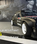 View of black Interlocking Diamond Plate Garage Floor Tiles for a Tough, Easy Clean Garage Makeover under a parked car.
