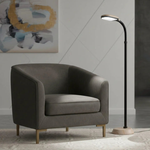 Adjustable Floor Lamp With Bendable Neck for Bedroom And Living Room next to armchair, woodgrain base in a modern setting.