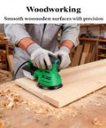 Person using green orbital sander with Dustless Sanding Discs Set 50 Pcs 5 Inch 8 Hole Round Sandpaper for wood polishing.