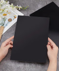 Person holding Two Black ABS Plastic Sheets 11.8 By 7.9 Inches 2mm Thick Hard Modeling Plastic For Architectural Models Sand Table Projects