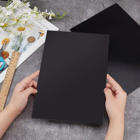 Person holding Two Black ABS Plastic Sheets 11.8 By 7.9 Inches 2mm Thick Hard Modeling Plastic For Architectural Models Sand Table Projects