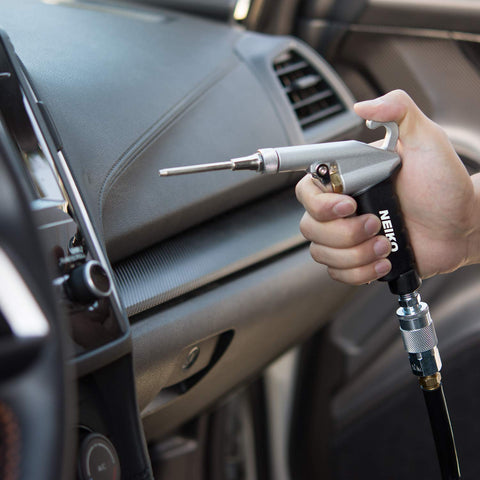 Hand using High Flow Air Blow Gun With Three Piece Pneumatic Nozzle Kit For Dust Debris And Wet Spills on car dashboard.