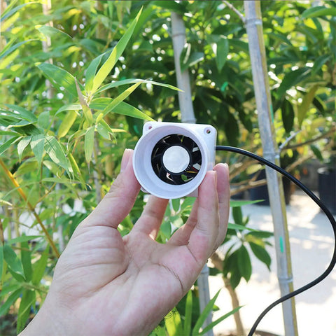 Hand holding Inline Duct Fan 2 Inch 50mm Kit With Adjustable Speed Quiet 62 CFM Ventilation Exhaust Booster in garden