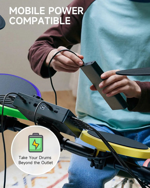 Child connecting USB Type C charger to kids electric drum set 7 piece with quiet silicone pads and 9 inch cymbals.