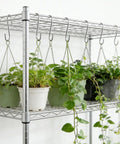 50 Pack 2.4 Inch Heavy Duty 304 Stainless Steel S Hooks For Kitchen Pots Pans Utensils Towels Tools Clothes And More No Rust Durable Hanging Hooks For Cabinets Racks Shelves displayed with hanging potted plants on a metal rack.