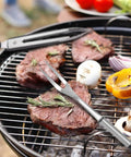 Ultimate Outdoor Camp Kitchen Utensils Set with grill fork handling steak and veggies on a campfire cookout.