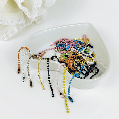 Assorted colorful beads chains in a bowl for crafts and keychain projects, similar to 50 Pcs 4 Inch Ball Beads Chain With Connectors.