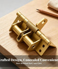 Automatic Concealed Self Closing Door Hinge With Heavy Duty Spring For Solid Wood Entryways in gold finish on wooden surface.