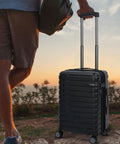 Traveler with Hard Shell Carry On Luggage With Spinner Wheels Expandable 21 Inch Cabin Suitcase Airline Approved at sunset