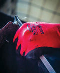 Close-up of Tsunami Grip Mach Finish Nitrile Coated Gloves with double dipped micro finish in use while handling metal object.