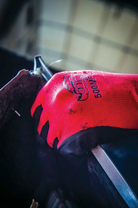 Close-up of Tsunami Grip Mach Finish Nitrile Coated Gloves with double dipped micro finish in use while handling metal object.