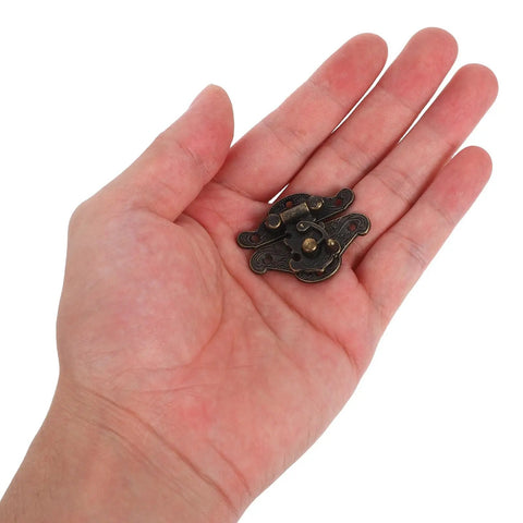 Close-up of 10 Pcs Antique Jewelry Box Latch Clasps Coffee Zinc Alloy with Screws held in hand for DIY craft repair.
