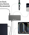 Top Shelf 12-In-1 Thunderbolt 5 Docking Station Featuring Integrated M.2 NVMe Bay Yields Dual 6K Outputs On Mac And Pushes Sick Triple 4K 144Hz Video For Creator Workstations Fr While Delivering A Rocksteady 140W PD Charge Cleanly, connected to a laptop, tablet, and smartwatch.