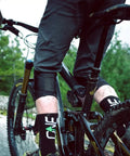 Shock Absorbing Bike Seatpost 31.6 X 400mm on mountain bike, rear view, rider on rough trail, red black finish, forest background
