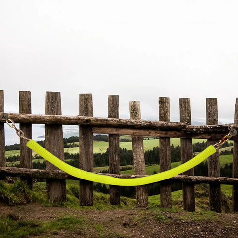 10 Ft High Visibility Chain Cover Kit In Bright Yellow For Indoor And Outdoor Barriers hanging on rustic fence