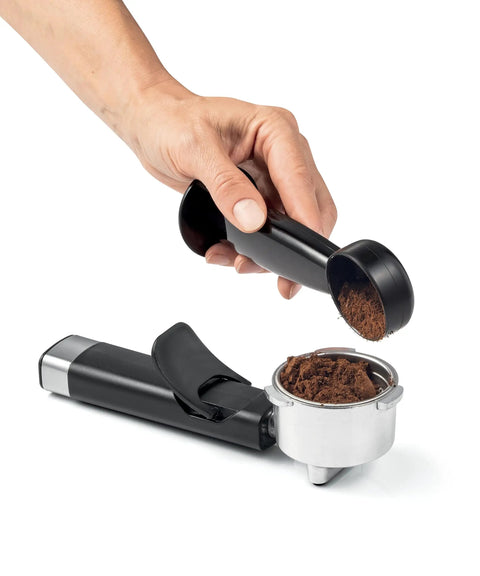Heavy Hitter 19 Bar Manual Espresso Machine With Integrated Milk Frother Dual Outlet Arms and Heated Base brewing grounds with a black tamper.